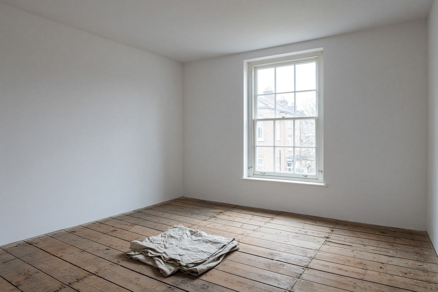 An empty room with a fresh skim coat on the walls and ceiling, ready for decoration
